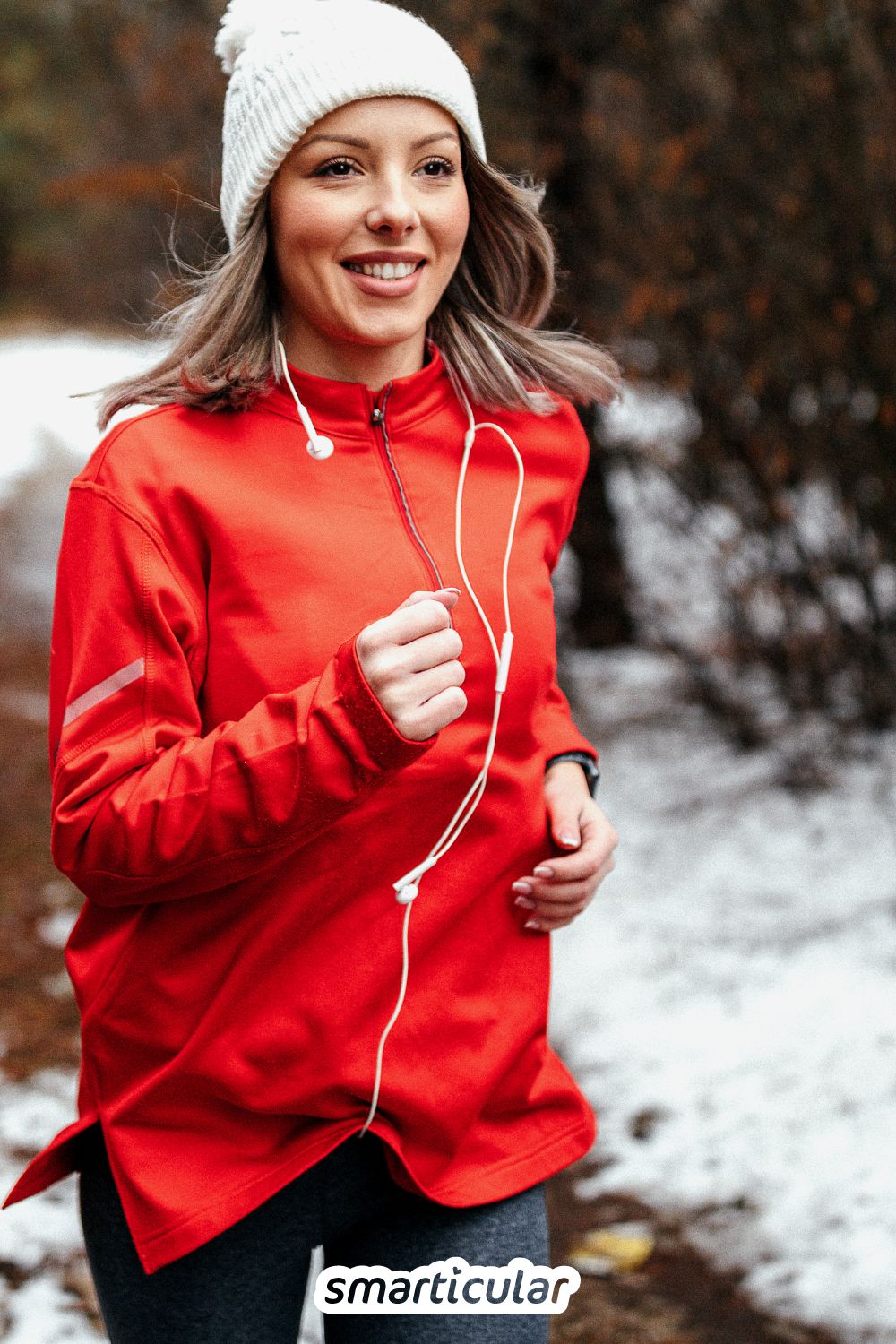 Eine Frau in rotem Anorak joggt